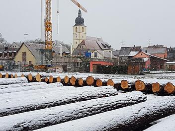 Annähernd die Hälfe des angebotenen Holzes lagert auf dem Wertholzplatz in Rentweinsdorf. Im Hintergrund ist neben der Dreieinigkeitskirche die Baustelle des Kindergartens zu sehen.  Foto: Eckehard Kiesewetter
