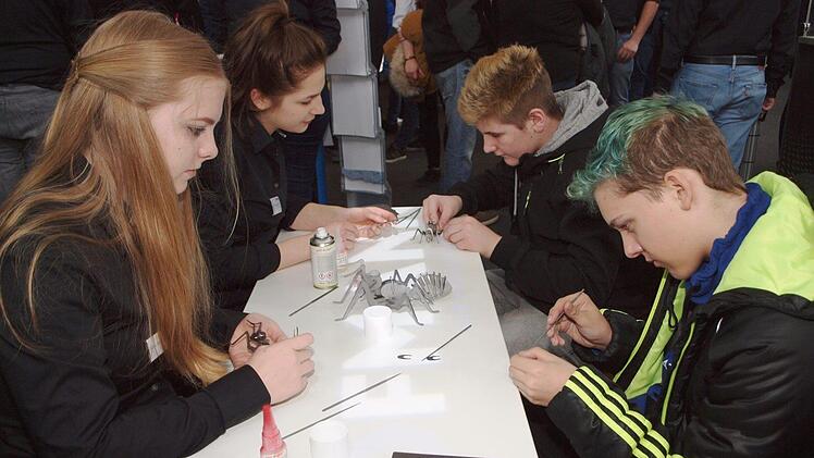 Marius Dinkel und Christian Schliebitz (von rechts), Schüler der Realschule Staffelstein, bauen am Stand von Robert Hofmann Ihr Möglichmacher mit Feilen und Kleben eine Ameise aus Metallteilen zusammen.  Foto: Alfred Thieret