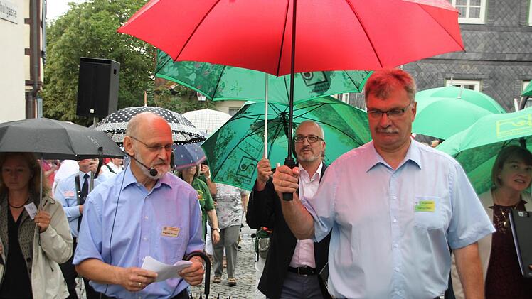 Regen? Kein Problem. Untermerzbachs Bürgermeister Helmut Dietz (rechts) und sein Stellvertreter Siegfried Kirchner moderierten den Rundgang souverän. Mitte, dahinter: Nikolai Kendzia, Juryvorsitzender