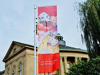 Eine Fahne von Eva Feichtinger weht vor dem Regentenbau auf der Ludwigsbrücke. Überall in der Stadt sind bis Ende Oktober derartige Kunstwerke zu sehen. Foto: Sigismund von Dobschütz