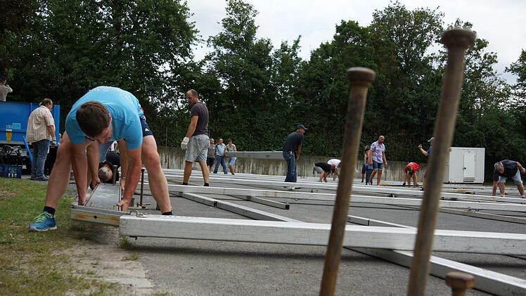 Beim Aufbau des Zelts helfen viele mit. Foto: Arkadius Guzy