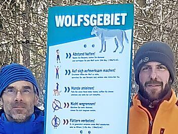 Karsten Gees und Sebastian B&auml;umler stellen eines der Warnschilder bei Begegnungen mit dem Wolf auf.