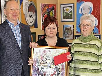 Pfarrer Jürgen Rix, Christina Flauder und Kirchenvorsteherin Gisela Findeisen bei der Spendenübergabe inmitten zahlreicher Werke von Ursula Wolf Foto: Katharina Müller-Sanke