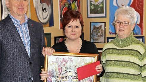 Pfarrer Jürgen Rix, Christina Flauder und Kirchenvorsteherin Gisela Findeisen bei der Spendenübergabe inmitten zahlreicher Werke von Ursula Wolf Foto: Katharina Müller-Sanke
