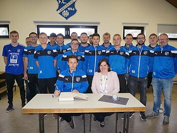 Die Meisterschaft der Mannschaft "SG Sandberg I und Waldberg II" in der  A-Klasse wurde mit einem Eintrag in das Goldene Buch der Gemeinde  Sandberg gebührend gewürdigt. Das Bild zeigt die Spieler,  Bürgermeisterin Sonja Reubelt mit Spielertrainer Florian Knüttel  (sitzend) und dem Vorsitzenden Christian Gleißner (rechts). Foto: Marion  Eckert