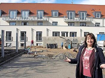 Martina Lutter vom Caritas-Kreisverband auf der Staffelsteiner Großbaustelle an der Ecke Victor-von-Scheffel-Straße/Am Kreuzberg. In den Räumen hinter der grauen Betonwand entstehen derzeit die Räume der ersten Senioren-WG für Demenzkranke im Landkreis.  Foto: Andreas Schmitt
