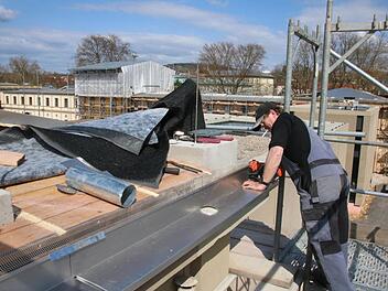 Peter Römmelt von der Spenglerei Wolf aus Donnersdorf ist einer der vielen Handwerker, die aktuell am Luitpoldbad arbeiten. Foto: Ralf Ruppert