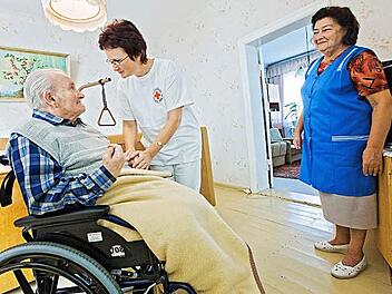 Eine Frau versorgt ihren pflegebedürftigen Mann - das ist häufig der Normalfall. In diesem Fall leistet eine Pflegeschwester vom Deutschen Roten Kreuz professionelle Unterstützung.  Foto: Archiv/epd