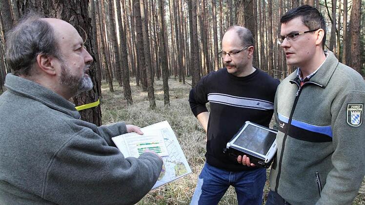 Forstdirektor Michael Kreppel (l.) und die neue Klimafachkraft Marco Kunz (r.) informieren Waldbesitzer Norbert Winkelmann darüber, welche Umbaumaßnahmen in dessen Wald in der Zukunft anstehen. Foto: Erlwein