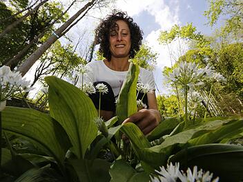 Andrea Bayer betrachtet eine Bärlauchpflanze.  Foto: Matthias Hoch
