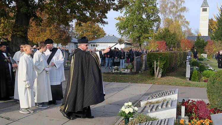 Besprengung des Priestergrabes mit Weihwasser  Foto: Johanna Blum