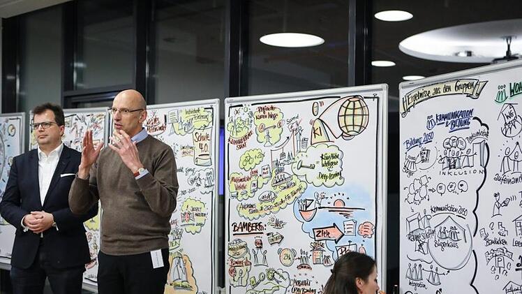Die von einer "graphic recorderin" in Bilder übersetzten Ergebnisse wurden von Anna Scherbaum (VHS) und Walter Schweinsberg (MGO) symbolisch an Bürgermeister Christian Lange übergeben. Foto: Barbara Herbst