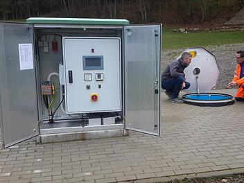 Dank des modernen Schaltschrankes (im Vordergrund) hat Wasserwart Cosimo Portarulo (hinten rechts) auch per Internet Zugriff auf die Anlage. Beim Ortstermin erläuterte er Bürgermeister Jochen Vogel (hinten links) die Funktion einer Einstiegsluke zu den Quellen.Foto: Rolf Pralle