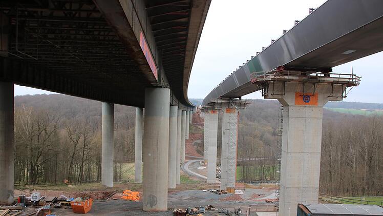Der Unterbau von einer der beiden neuen Autobahnbrücken über dem Thulbatal ist mittlerweile fertig. Nun wird die Fahrbahnplatte betoniert, ab Mitte 2023 soll dann die alte Brücke (links) abgerissen werden.