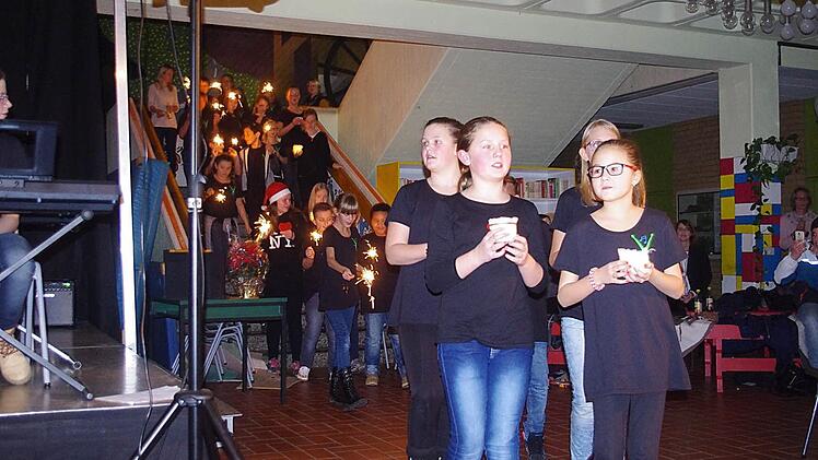Beim "Heal the world" zogen die Mitwirkenden mit leuchtenden Lichtern in die Aula ein. Foto: Heike Schülein