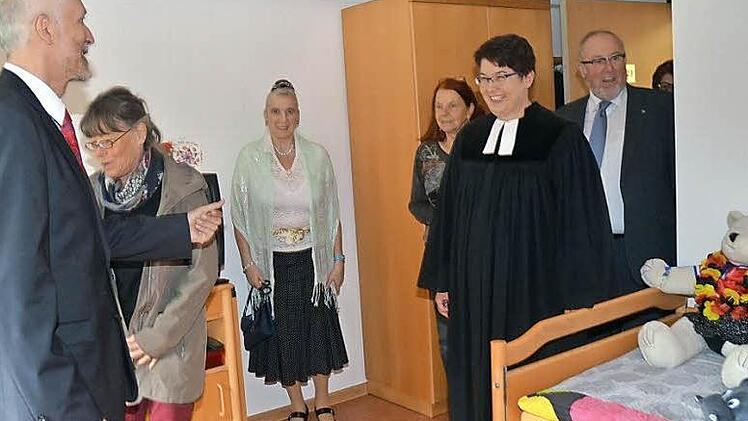 Eine Bewohnerin (Dritte von links) und Heimleiter Gerhard Steidl (links) zeigen eines der individuell eingerichteten Einzelzimmer. Fotos: Hofmann