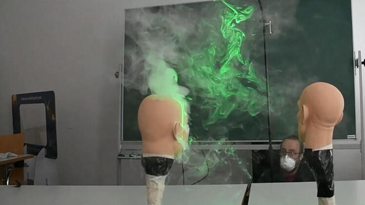 Michael Florschütz betrachtet die Versuchsanordnung: Hier zeigt sich, wie Aerosole trotz Maske zum Banknachbarn geraten können. Foto: Hochschule Coburg