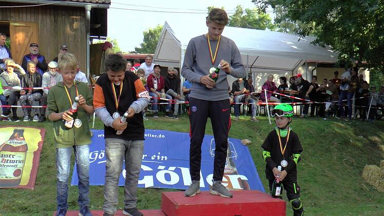 Die feucht-fröhliche Siegerehrung in der leichte Fahrzeugklasse: 1. Platz Robin Hehn ("Carlos") aus Sechsthal, 2. Platz Elias und Philipp Hetterich ("Bratwurstflitzer") aus Zeil, 3. Platz Emil Hemetsberger ("Gecko") aus Königsberg, der das Aufmachen von Sektflaschen noch etwas üben musste.