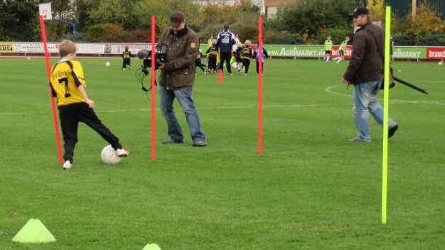 Dribbeln durch und um die Torstangen: Anton Johann von der D-Jugend (Trikotnummer 7) zeigt den Fernsehleuten, wie gut er das kann.