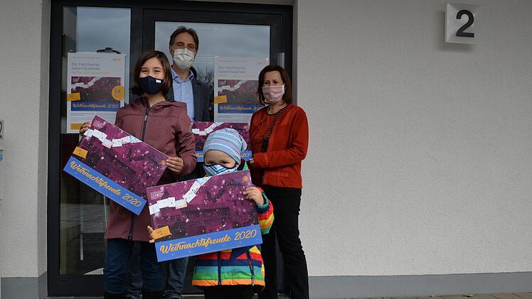 Johanna (10 Jahre alt) und ihr  Bruder Max (3) sowie  Stefan Alexander, Präsident des Rotary-Clubs Forchheim, und Lisa Hümmer, Vorsitzende des Kinderschutzbundes, präsentieren den Kalender. Foto: Franka Struve-Waasner