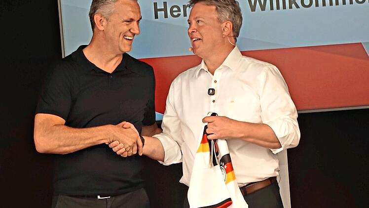 Oliver Rosic &uuml;berreicht eine Dokumentation des Baufortschritts und ein Fu&szlig;balltrikot an Ralf Klein.