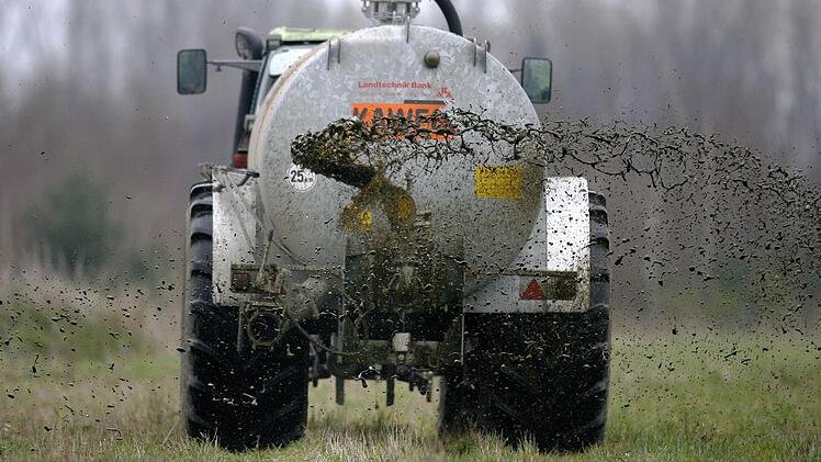 Ein Bauer bringt Gülle auf seinem Feld aus.  Foto: Jochen Lübke/dpa