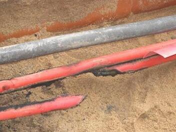 Das 20-kv-Kabel ist auseinander gerissen.  Die Überspannung zerlegte das Kabel. Deutlich erkennbar sind die Schmauchspuren an der roten Kabelummantelung. Foto: Stadtwerke Zeil