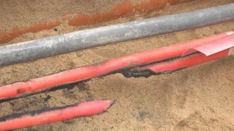Das 20-kv-Kabel ist auseinander gerissen.  Die Überspannung zerlegte das Kabel. Deutlich erkennbar sind die Schmauchspuren an der roten Kabelummantelung. Foto: Stadtwerke Zeil