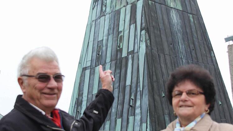 Mesner Berthold Suffa und Kirchenpflegerin Margit Rebhan vor dem Kirchturm mit den ganz besonderen Zifferblättern  Foto: Friedwald Schedel