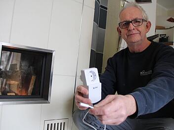 Ofenbauer Hans-Werner Denzler zeigt einen Fensterschutzschalter. Die Dunstabzugshaube hängt am Stecker. Der kleine Magnetschalter kommt an das Fenster. Durch einen Stromimpuls auf den Steckdosenempfänger weiß die Haube: Achtung, Fenster ist geschlossen.  Foto: Christian Bauriedel