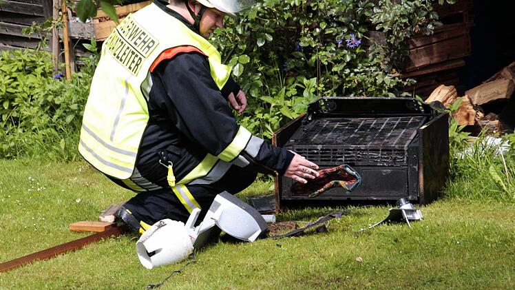Der Einsatzleiter kontrolliert noch einmal die verkohlte Dunstabzugshaube. Sie ist immer noch sehr heiß.  Foto: Josef Hofbauer
