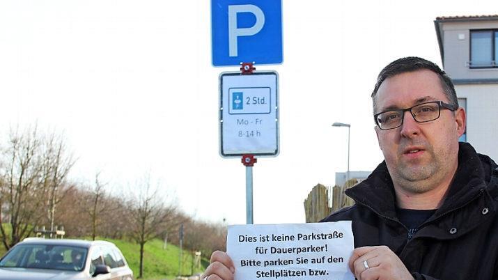 Stefan Bischof verdeutlicht den Protest der Bewohner. Die Stadt hat zwischenzeitlich mit einer Parkscheibenregelung in zwei Straßen reagiert.  Fotos: Bernhard Panzer