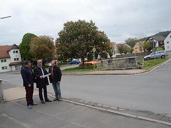 Bürgermeister Rainer Detsch (Mitte) und Geschäftsleiter Rainer Förtsch (links) mit Bauhofleiter Günter Hempfling zeigen den Kernpunkt der Arbeiten in der Ortsmitte, die ab Dienstag kommender Woche zu einer Vollsperrung der Ortsdurchfahrt in Reitsch führen werden. Die Brücke vorne wird vollständig erneuert, die Straße rechts wird in der Ein- und Ausfahrt verbreitert. Foto: K.- H. Hofmann