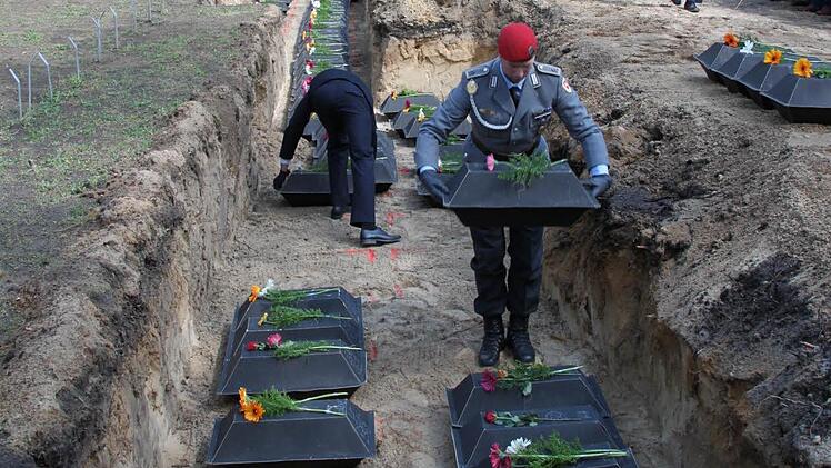 Die sterblichen Überreste vieler Soldaten, die bei Halbe gestorben sind, werden auf dem Waldfriedhof an ihre letzte Ruhestätte gebracht.