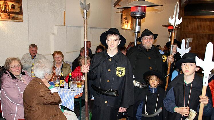 In Bad Rodach sind donnerstags ab sofort wieder die Nachtwächter unterwegs. Wegen des Dauerregens am Donnerstagabend fand der Auftakt nicht am historischen Pulverturm, sondern in der Scheune des Café Faudler statt, wo die Nachtwächter Karl-Heinz Engelhardt (Zweiter von links) und Samuel Schmidt (links) das Publikum mit ihren Versen unterhielten. Auch der fünfjährige José Ramón Kienel (Drittter von links) ist schon mit Begeisterung dabei. Foto: Bettina Knauth