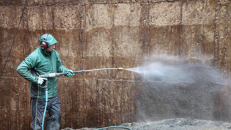 Den unteren Teil der Betonwände spritzen die Arbeiter vom Boden aus ab.  Foto: Andreas Schmitt