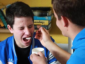 Dario füttert Felix. Damit beide Schüler nachvollziehen können, wie sich alte Menschen fühlen und gepflegt werden müssen, hat Felix dabei seine Augen geschlossen.Foto: Sarah Dann