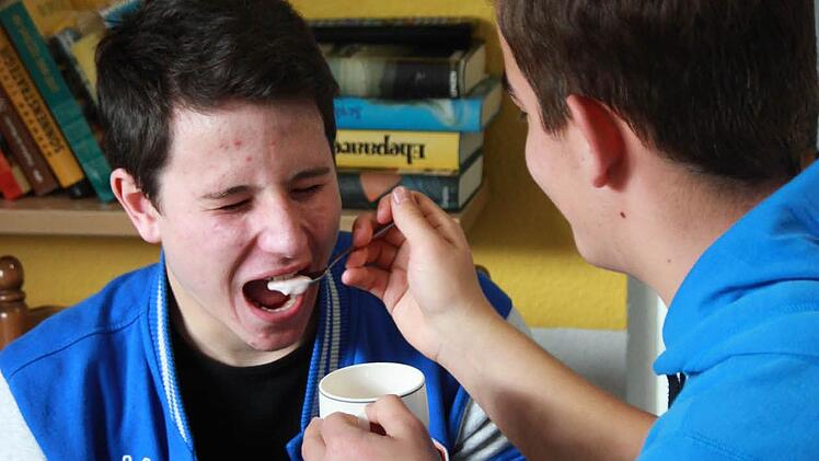 Dario füttert Felix. Damit beide Schüler nachvollziehen können, wie sich alte Menschen fühlen und gepflegt werden müssen, hat Felix dabei seine Augen geschlossen.Foto: Sarah Dann