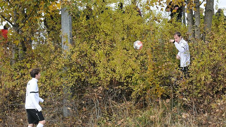 Gleich zwei      Spieler der SG Oehrberg suchen - und finden den Ball im Gestrüpp am Hügel des Sportplatzes.  Foto: ssp
