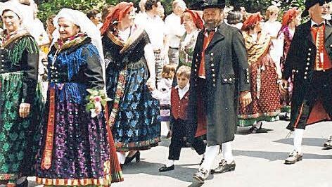 Die Frauen mit traditionell gebundenen Kopftüchern zur Tracht und Männer mit dem Dreispitz sind ein Hingucker bei Umzügen.