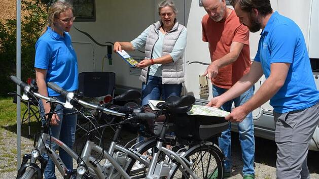 Wander- und Radkarten geh&ouml;ren zur Willkommenst&uuml;te in Bad Rodach: Stine Michel, Alrun und Dieter Huyke und Ren&eacute; Michel am Wohnmobil der Huykes.  Foto: Gabi Bertram