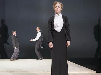 Hedda Gabler (Anna Keil) als Schmerzensfrau im Vordergrund der kahlen Bühne, im Hintergrund Richter Brack (Pius Maria Cüppers, li.) und Jørgen Tesman (Stefan Lorch, re.) Fotos: Marion Bührle