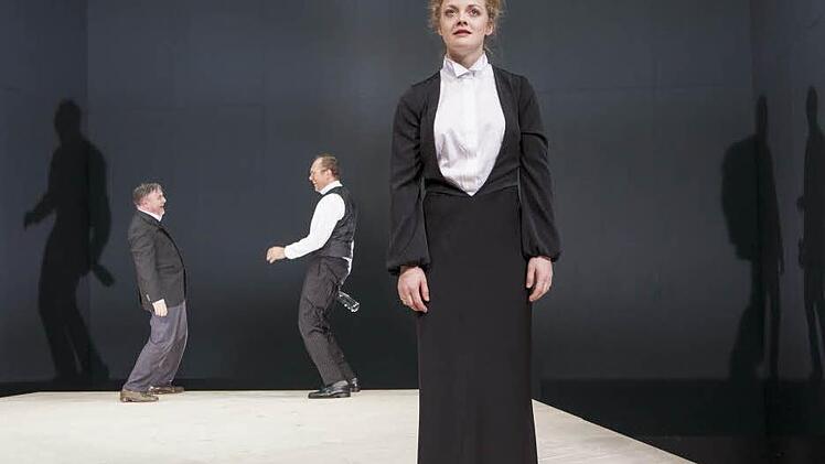 Hedda Gabler (Anna Keil) als Schmerzensfrau im Vordergrund der kahlen Bühne, im Hintergrund Richter Brack (Pius Maria Cüppers, li.) und Jørgen Tesman (Stefan Lorch, re.) Fotos: Marion Bührle