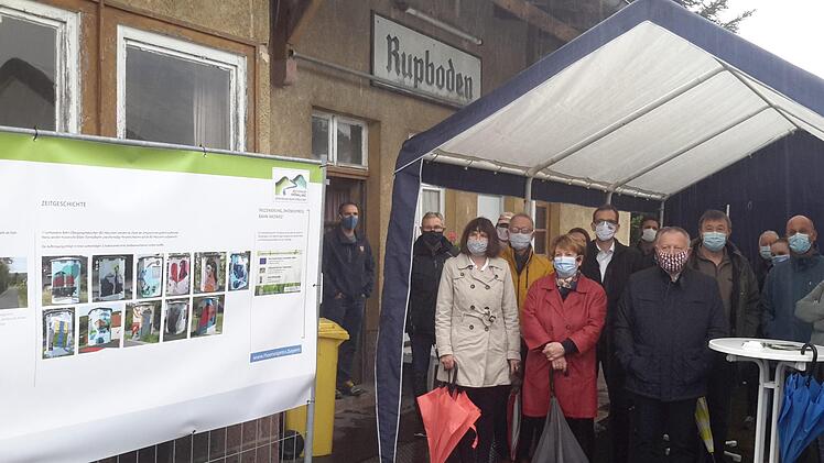 Bei anhaltendem Regen sehr begehrt waren die trockenen Stehplätze im provisorisch aufgestellten Zelt. Auch von dort hatten die Gäste bei den Grußworten der Redner einen guten Blick auf die Schautafeln (links im Bild). Foto: Rolf Pralle