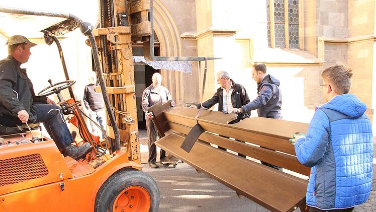 Helfer transportieren die Bänke aus dem Altarraum ab.Heike Beudert