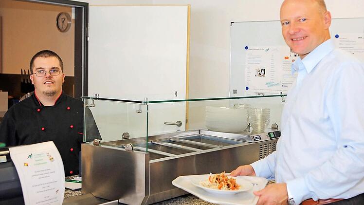Christian Gampert an seinem Arbeitsplatz, der Betriebskantine der Firma Loesch Verpackungstechnik GmbH. Rechts im Bild Geschäftsführer Andreas Graf.  Fotos: RiegerPress