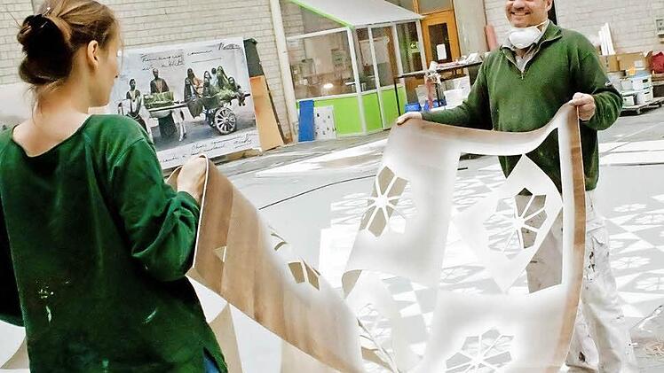 Eva Meininger und Malsaalvorstand Rainer Schirmer mit einer Matrize, mit der die Muster für das Bodentuch für den "Barbier von Bagdad" hergestellt werden. Die komische Oper von Peter Cornelius feiert am 27. April Premiere am Landestheater. Fotos: Jochen Berger