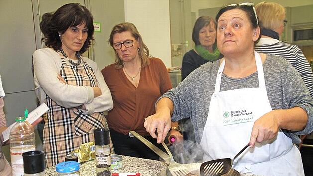 Monika Gerner (r.) wirft einen pr&uuml;fenden Blick zur Uhr zur Stirnseite der Lehrk&uuml;che. Nach drei Minuten wendet sie das Rumpsteak. Foto: Gerda V&ouml;lk