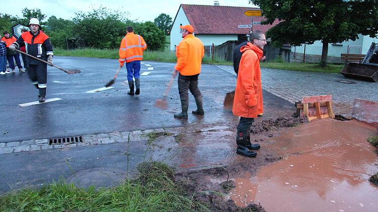 Kleine wasserführende Gräben schwollen an und verstopften die Abflüsse. Helfer der Feuerwehr versuchten in Fischbach Abhilfe zu schaffen. Foto: Michael Will