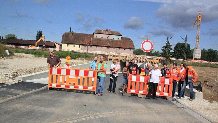 Bürgermeister Bernhard Storath (links) räumte die Baustellensperre zur Seite und gab die Unterführung für den Verkehr frei. Einige Ebensfelder Bürger hatten sich zur Freigabe der Trasse eingefunden - Beifall gab es jedoch nicht. Foto: Matthias Einwag